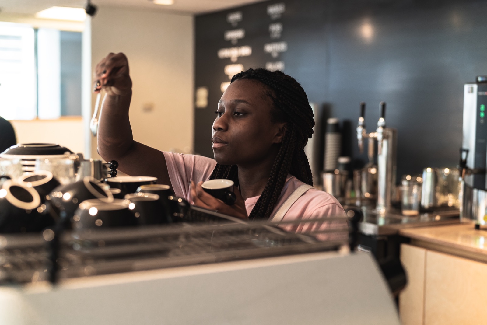 A barista crafting drinks behind the counter at Huge Café