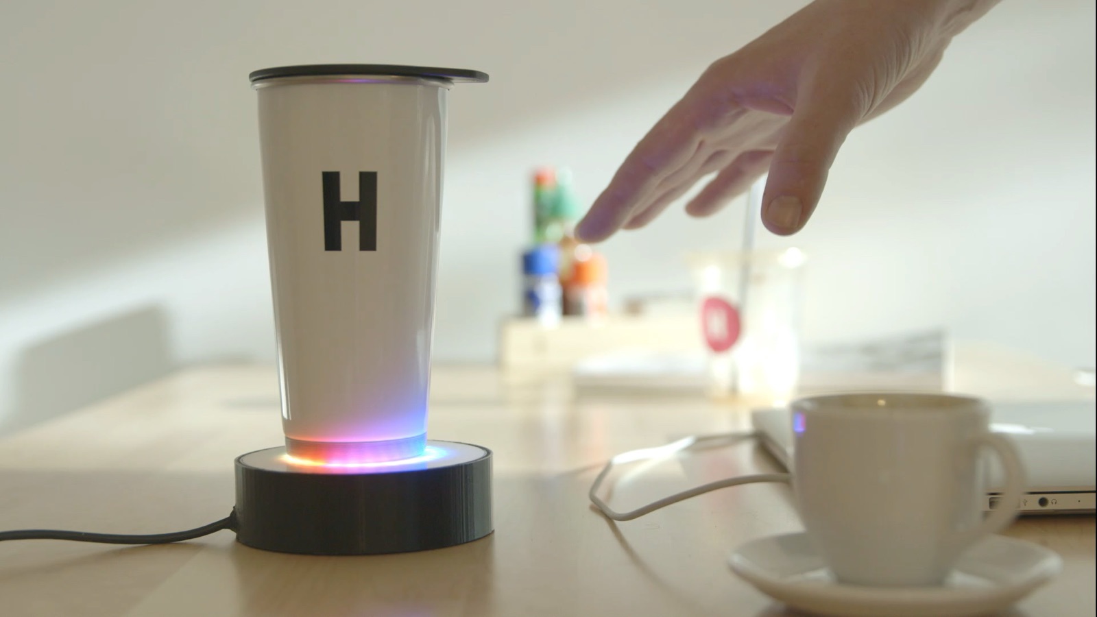 An RFID-enabled smart vessel on its illuminated pedestal, with multicolor LED feedback indicating a successful read